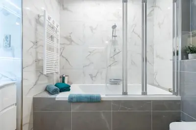 a white bathroom with a tub and a shower at Large Haussmanian appartment in the heart of Nice in Nice