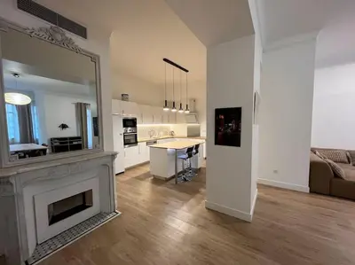 a living room with a fireplace and a large mirror at Large Haussmanian appartment in the heart of Nice in Nice