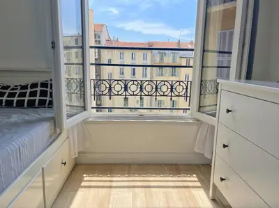 a bedroom with a bed and a large window at Studio au coeur de Nice in Nice