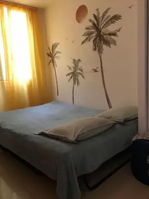 a bedroom with a bed with palm trees on the wall at Summer Beach Studio, 4 persons, mobile AC, Old Town in Nice