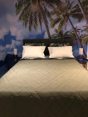 a bedroom with a large bed with palm trees on the wall at Summer Beach Studio, 4 persons, mobile AC, Old Town in Nice