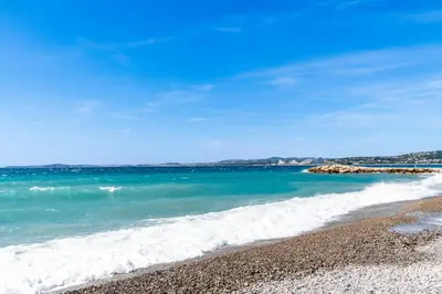a view of the ocean from a rocky beach at Résidence méditerranée - Beachfront - Sun and Seaview - Pool - Private Parking in Cagnes-sur-Mer