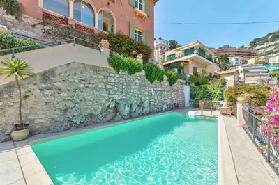 a swimming pool in front of a building at Villa Francesca Beautiful villa with sea view and swimming pool! in Villefranche-sur-Mer