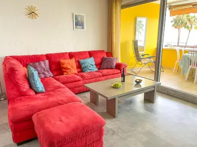 a living room with a red couch and a table at Horizon in Saint-Laurent-du-Var