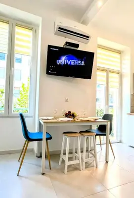 a dining room with a table and chairs and a tv at Cozy T2 - Lovely Balcony - Center - Liberation - Clim - WIFI in Nice