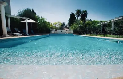 a large swimming pool with blue water at Villa prestigieuse avec piscine privée au cœur de Nice in Nice