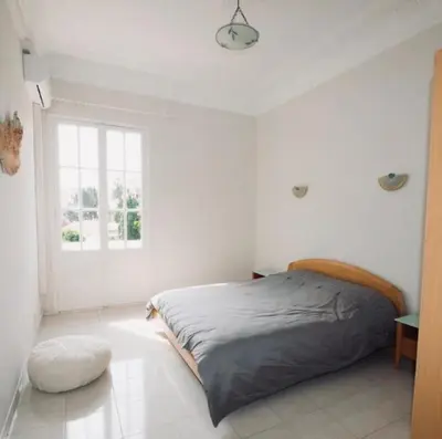 a white bedroom with a bed and a window at Villa prestigieuse avec piscine privée au cœur de Nice in Nice