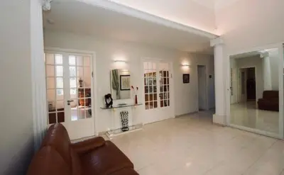 a living room with a brown couch and a room with a couch at Villa prestigieuse avec piscine privée au cœur de Nice in Nice