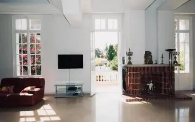 a living room with a couch and a tv at Villa prestigieuse avec piscine privée au cœur de Nice in Nice