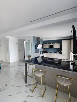 a kitchen with a black counter and two chairs at Beach front, Superbe appartement pour 4 personnes in Nice