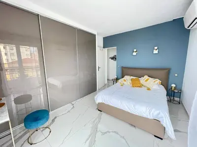 a bedroom with a large bed and a blue wall at Beach front, Superbe appartement pour 4 personnes in Nice