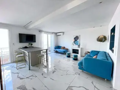 a living room with a blue couch and a table at Beach front, Superbe appartement pour 4 personnes in Nice