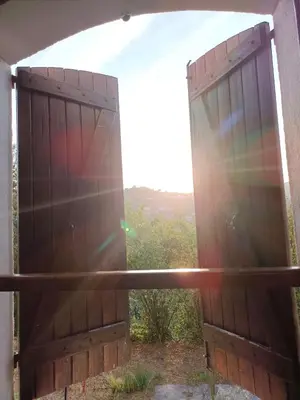 an open gate with the sun shining through at Joli 3p - Bas de villa in Saint-Andre-de-la-Roche