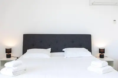 a white bed with white pillows and two lamps at L43 Suite Maurice sea view 6Pax/Terrace,Parking,AC in Saint-Laurent-du-Var