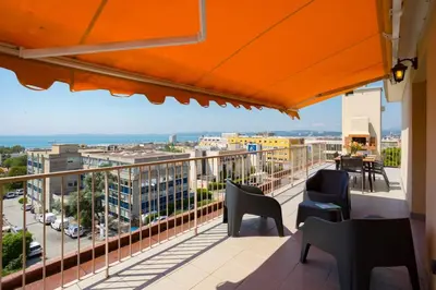 a balcony with chairs and a view of a city at L43 Suite Maurice sea view 6Pax/Terrace,Parking,AC in Saint-Laurent-du-Var