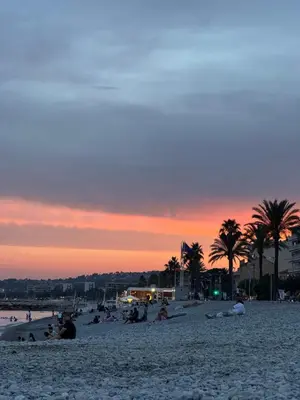 a group of people on a beach at sunset at Studio proche mer avec piscine Cros de cagnes in Cagnes-sur-Mer