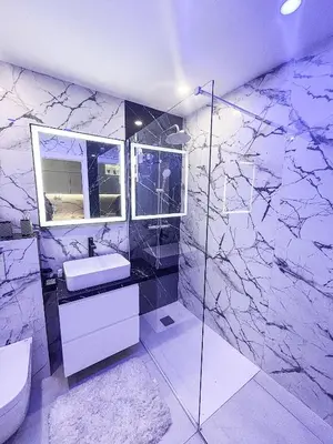 a bathroom with marble walls and a sink and a mirror at Promenade-des-anglais-front-sea in Nice