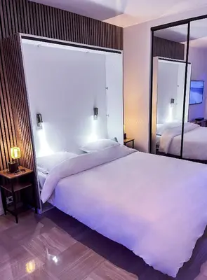 a bedroom with a large white bed and a mirror at Promenade-des-anglais-front-sea in Nice