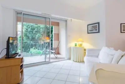 a living room with a couch and a sliding glass door at St JEAN CAP FERRAT CENTRAL CONTEMPORARY LOVELY WIFI in Saint-Jean-Cap-Ferrat
