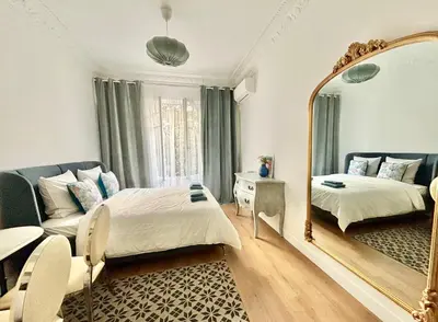 a bedroom with a mirror and a bed and a couch at Studio 2 steps from the sea near the Negresco hotel in Nice