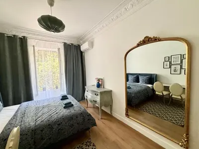 a bedroom with a bed and a large mirror at Studio 2 steps from the sea near the Negresco hotel in Nice