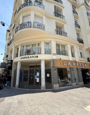 a large building on a street with people standing outside at Studio 2 steps from the sea near the Negresco hotel in Nice