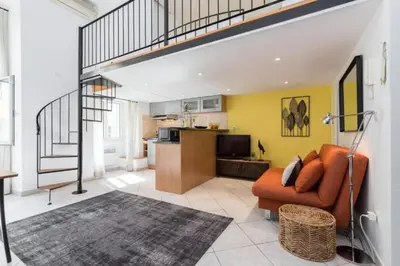a living room with an orange couch and a kitchen at MY CASA - MASSENA 2 - Great location Massena Square with AC in Nice