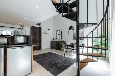 a kitchen and living room with a spiral staircase at MY CASA - MASSENA 2 - Great location Massena Square with AC in Nice