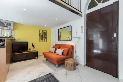 a living room with an orange couch and a television at MY CASA - MASSENA 2 - Great location Massena Square with AC in Nice