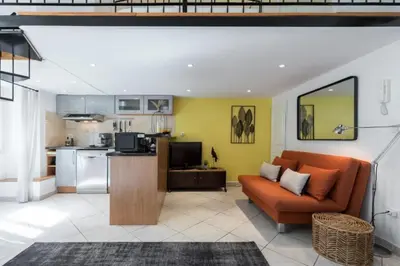 a living room with an orange couch and a kitchen at MY CASA - MASSENA 2 - Great location Massena Square with AC in Nice