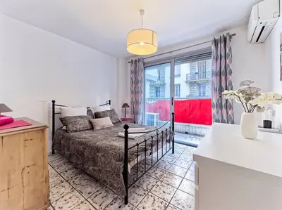 a bedroom with a bed and a large window at Superbe Appartement Près de la Gare-Clim-Wifi-Espace dedié au Travail in Nice