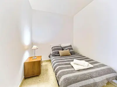a bedroom with a striped bed with a night stand at Superbe Appartement Près de la Gare-Clim-Wifi-Espace dedié au Travail in Nice