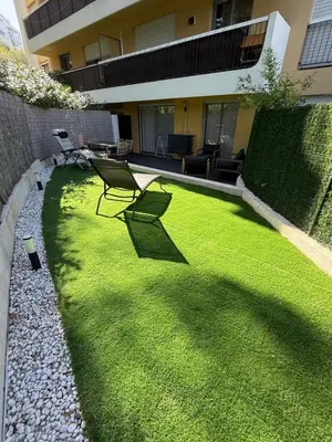 a grassy yard with a chair in front of a building at Papillon de cimiez in Nice