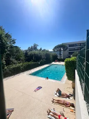 a group of people laying around a swimming pool at Papillon de cimiez in Nice