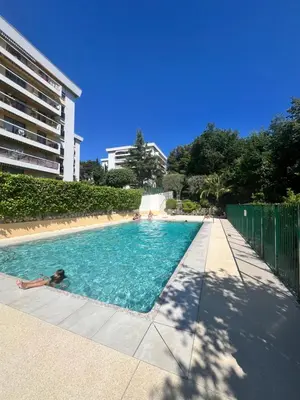 a person laying in a swimming pool at Papillon de cimiez in Nice
