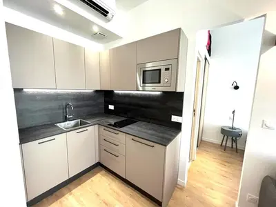 a kitchen with white cabinets and a sink and a microwave at Hypercentre lamartine 404 in Nice