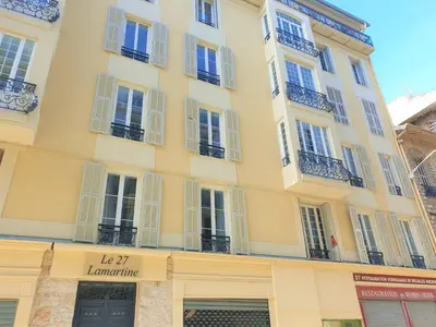 a large yellow building with white windows and balconies at Hypercentre lamartine 404 in Nice