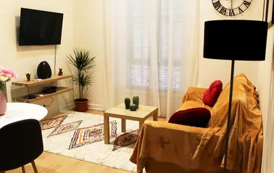 a living room with a couch and a clock on the wall at Lofty - Massena sq - 5 min walk Beach in Nice