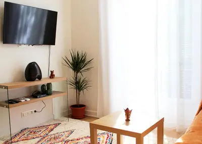 a living room with a tv and a table at Lofty - Massena sq - 5 min walk Beach in Nice