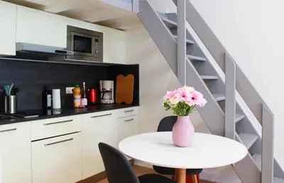a vase of flowers on a table in a kitchen at Lofty - Massena sq - 5 min walk Beach in Nice