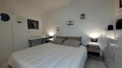 a bedroom with a large white bed and two lamps at BEACH APPART in Nice