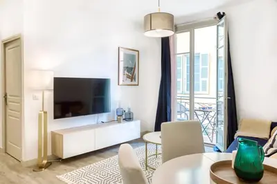 a living room with a television and a table and chairs at #44 1 BDR Flat Cap AC balcony 5mins walk to beach in Nice