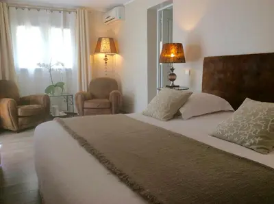 a bedroom with a large bed with two lamps and chairs at Villa Kilauea B&B in Nice
