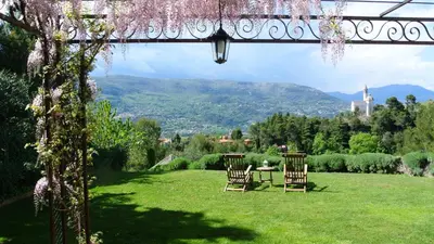 two chairs and a table in a field with mountains at Villa Kilauea B&B in Nice