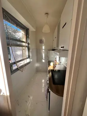 a small kitchen with white cabinets and a window at Cros de Cagnes, apartment with the Best Location in Cagnes-sur-Mer