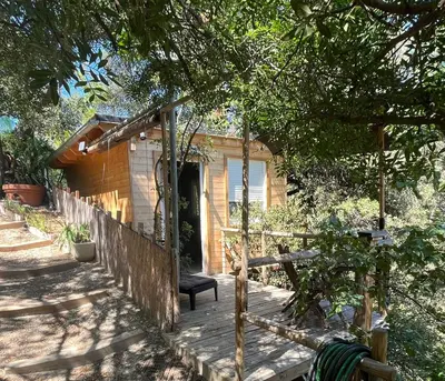 a wooden porch with a chair on a house at Chalet dans les arbres in Nice