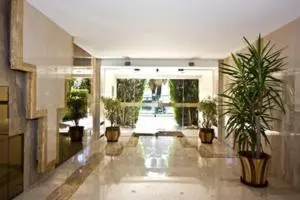 a large hallway with potted plants in a building at L'Azur Promenade in Nice
