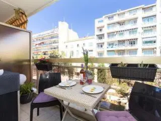 a table and chairs on a balcony with a building at L'Azur Promenade in Nice