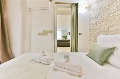 a bedroom with a white bed with towels on it at Grand appartement- Le Port A/C in Nice