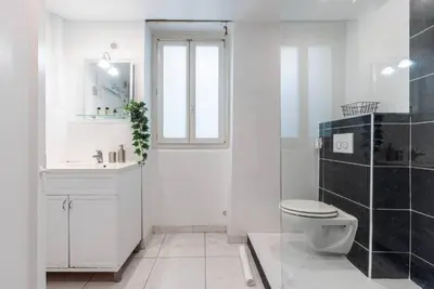 a white bathroom with a toilet and a sink at Grand appartement- Le Port A/C in Nice